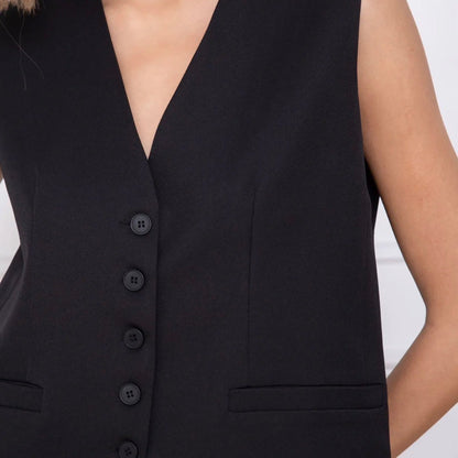 Model wearing KIDDING black tailored suiting vest as a standalone top with matching trousers, gold necklace, and sunglasses