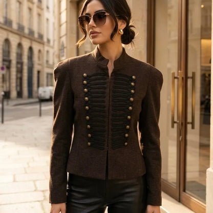 Model wearing KIDDING espresso brown wool military jacket with black braided frogging, antique brass buttons, and Mandarin collar paired with black leather pants
