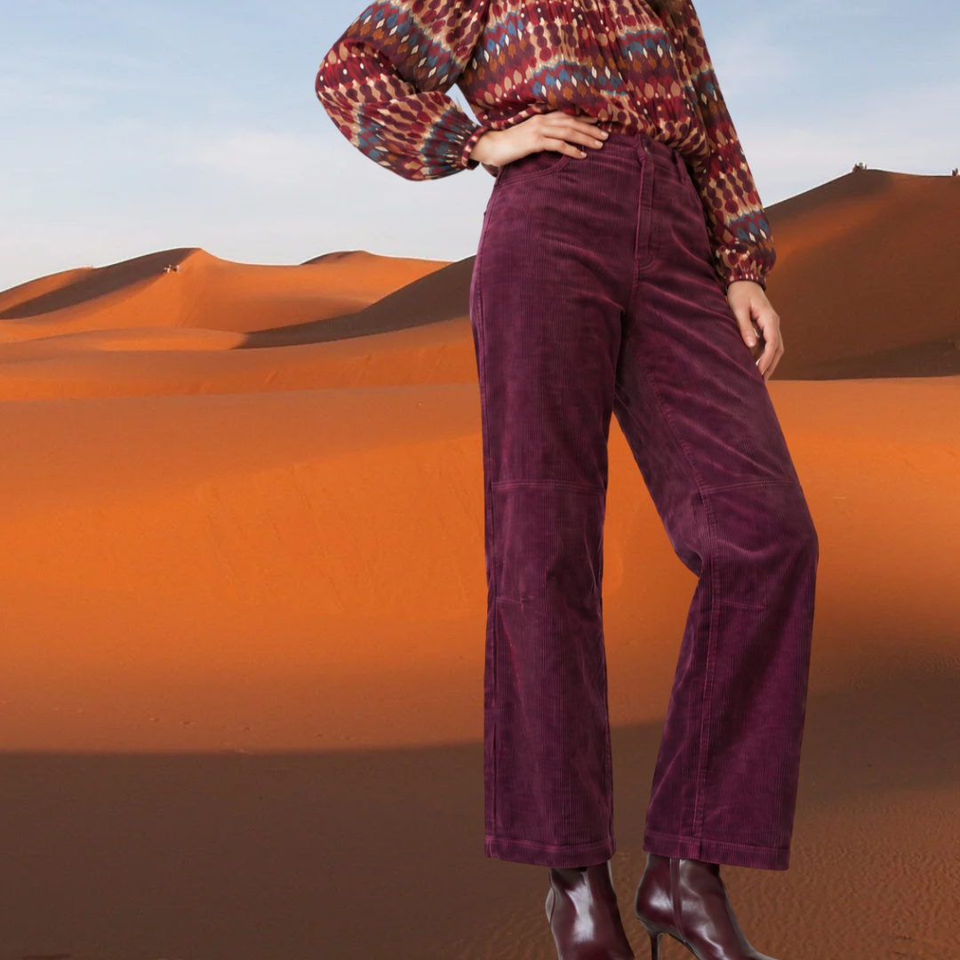 Front view of a kidding high-waisted, straight-leg plum corduroy trousers featuring horizontal knee-seam details, styled with burgundy leather boots.